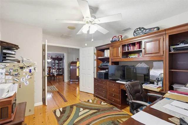 a view of a hallway with wooden floor and windows