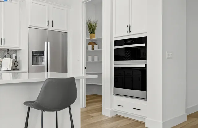 a kitchen with granite countertop a refrigerator and a stove top oven
