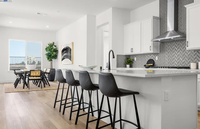 a kitchen with stainless steel appliances a table and chairs in it