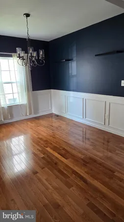 a view of a livingroom with an empty space wooden floor and windows