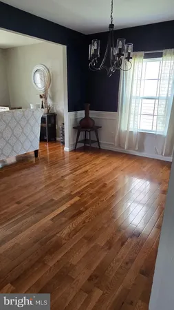 a view of a hallway with wooden floor and windows