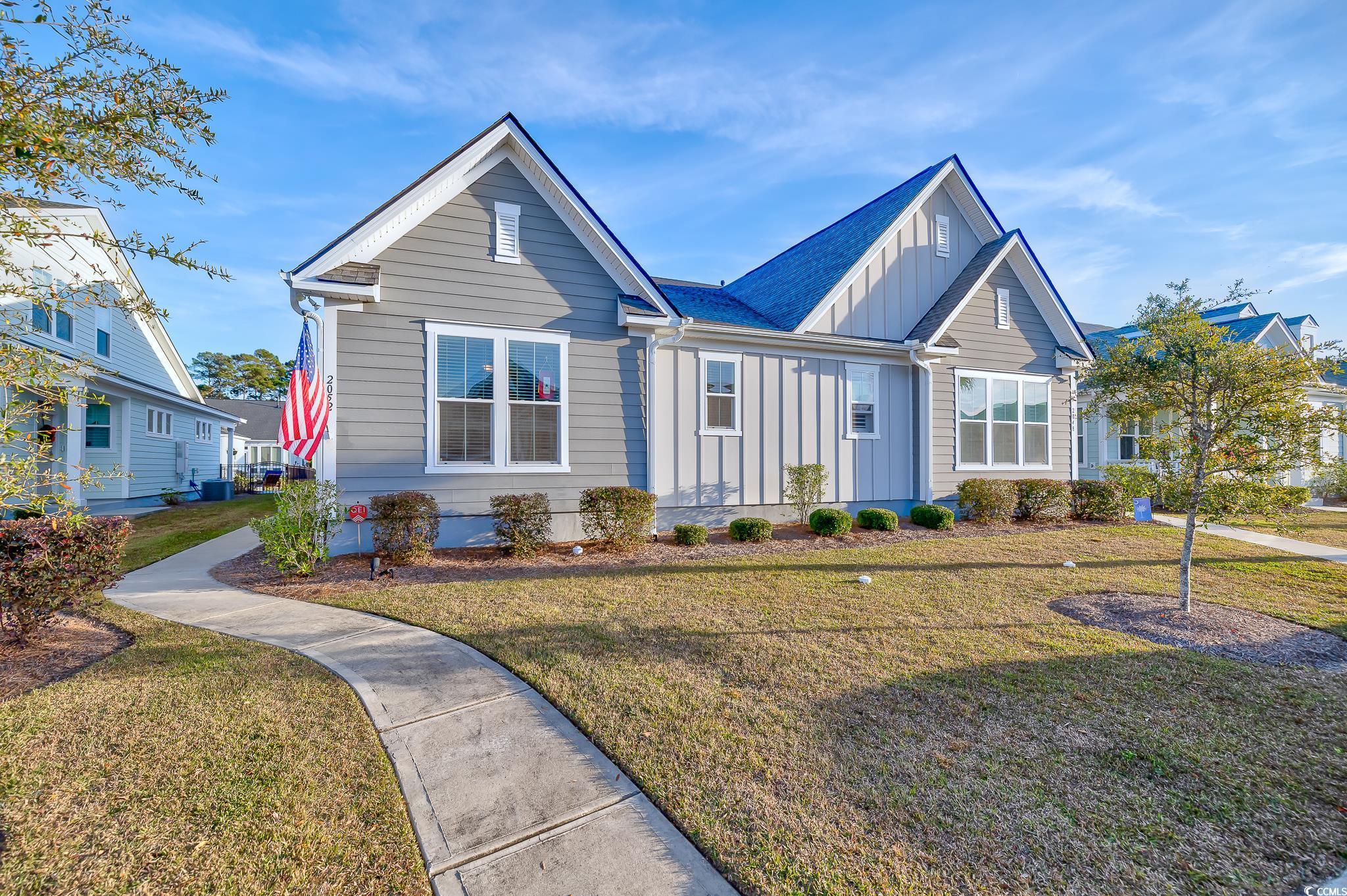 View of front of house featuring board and batten siding and a front yard
