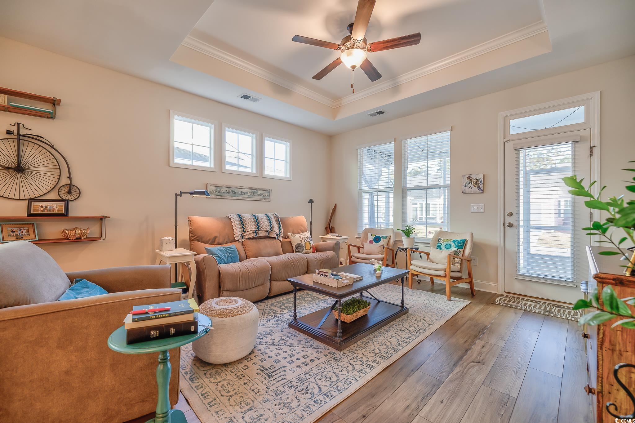 2052 Silver Island Way Murrells Inlet, SC 29576 - Photo 24 of 24 Living room featuring wood-type flooring, crown molding, a ceiling fan, and a tray ceiling