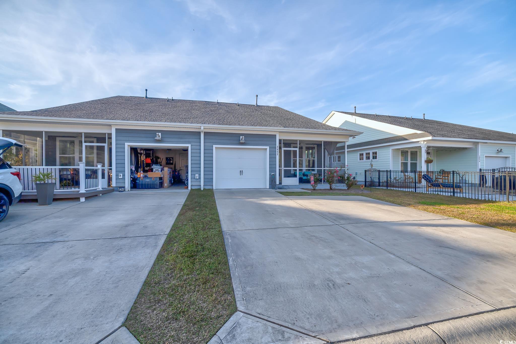 2052 Silver Island Way Murrells Inlet, SC 29576 - Photo 8 of 24 Ranch-style house with a sunroom, concrete driveway, a shingled roof, and an attached garage