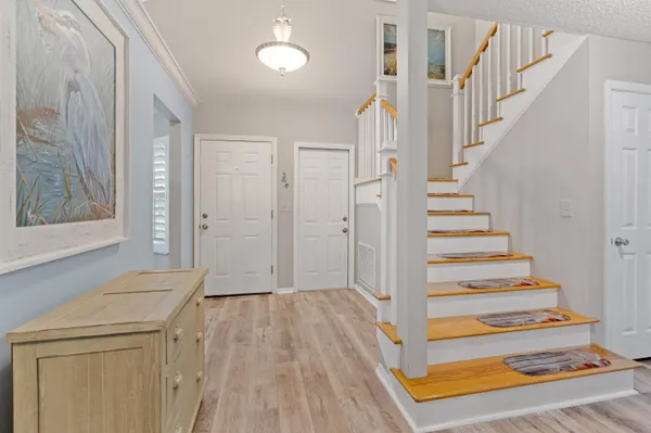 a view of a hallway with wooden floor and entryway
