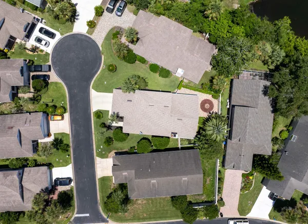 an aerial view of a house with a yard and large trees