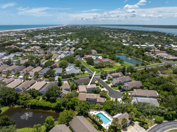 an aerial view of residential houses with outdoor space and lake view