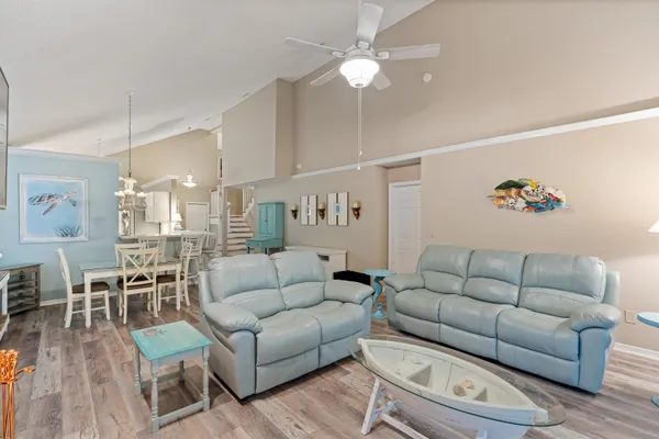 a living room with furniture kitchen view and a chandelier