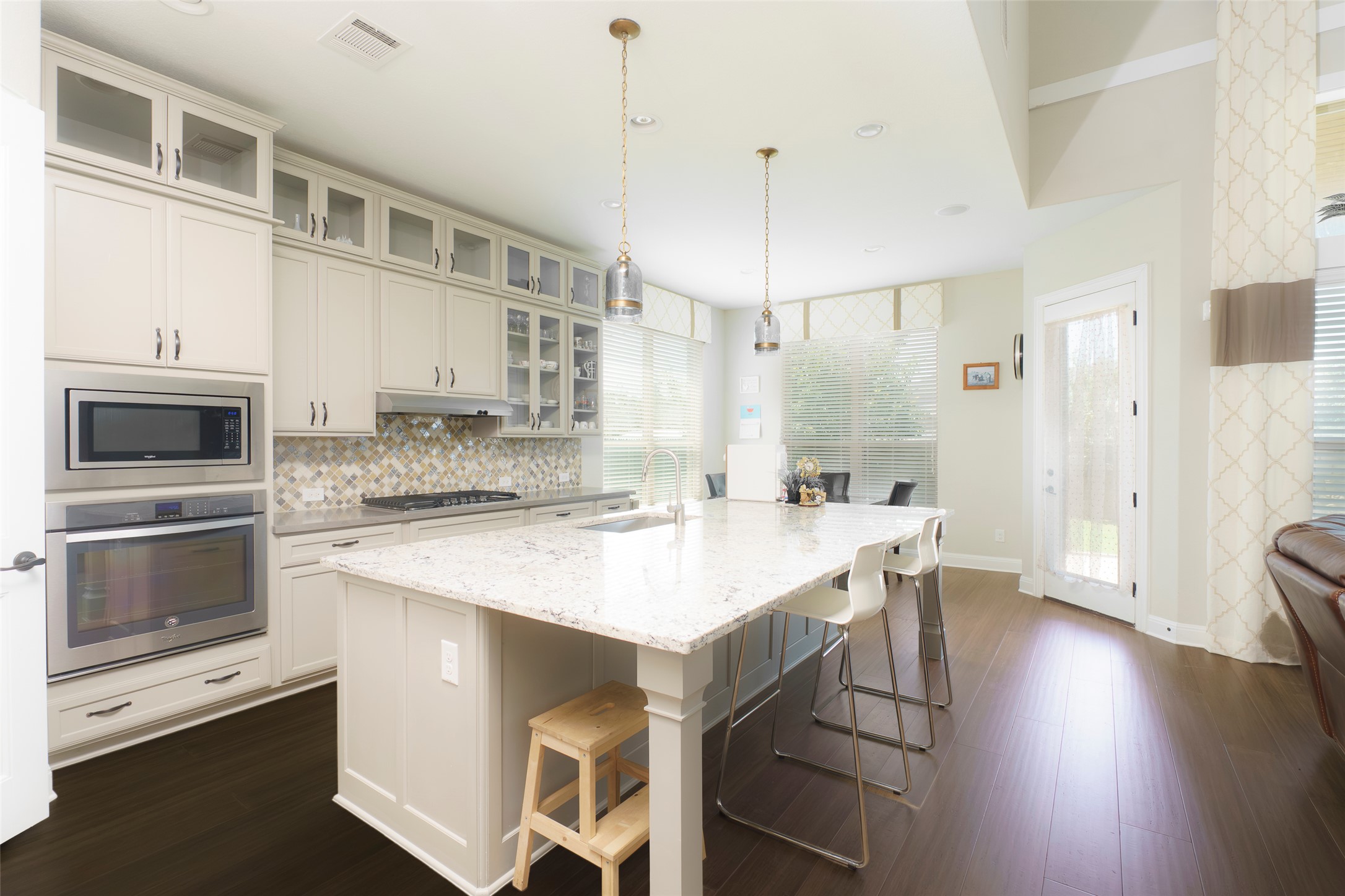 2305 Millbrook Loop Leander, TX 78641 - Photo 4 of 26 Culinary aspirations meet elegant design in this luminous kitchen featuring an expansive central island and rich hardwood flooring.