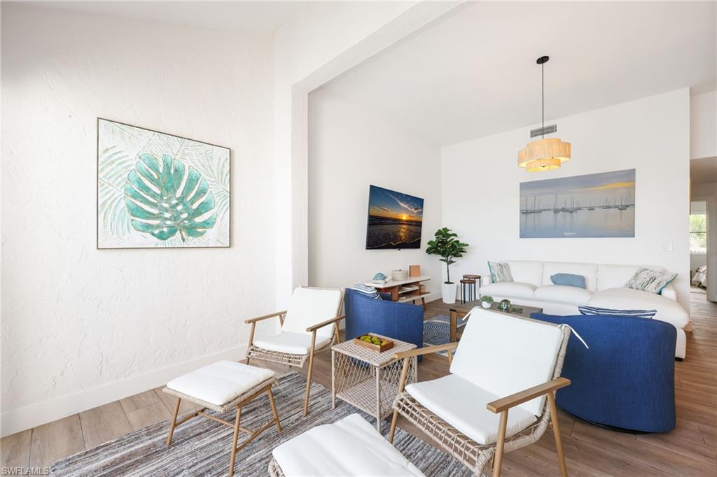 2711 Citrus Lake Drive, Unit F305 Naples, FL 34109 - Photo 13 of 50 a living room with furniture a flat screen tv and a window