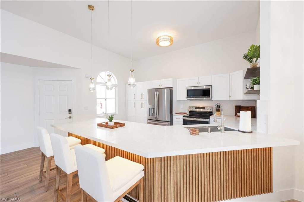 2711 Citrus Lake Drive, Unit F305 Naples, FL 34109 - Photo 14 of 50 a dinning room with stainless steel appliances a table and chairs