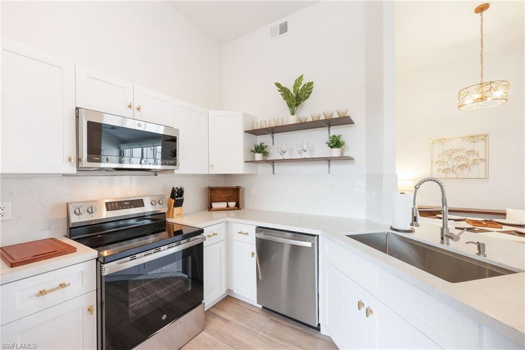 2711 Citrus Lake Drive, Unit F305 Naples, FL 34109 - Photo 16 of 50 a kitchen with a sink stove and microwave