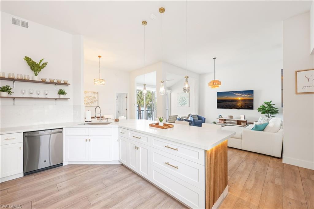 2711 Citrus Lake Drive, Unit F305 Naples, FL 34109 - Photo 17 of 50 a view of a kitchen with kitchen island a sink stainless steel appliances and cabinets