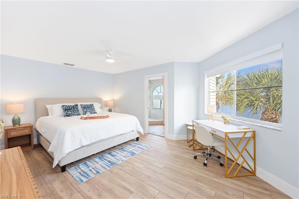 2711 Citrus Lake Drive, Unit F305 Naples, FL 34109 - Photo 21 of 50 a bedroom with a bed a table and chair with wooden floor