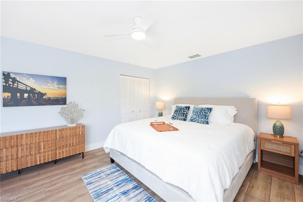 2711 Citrus Lake Drive, Unit F305 Naples, FL 34109 - Photo 22 of 50 a bedroom with a bed and wooden floor