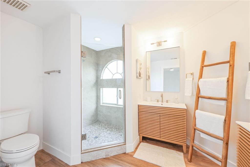2711 Citrus Lake Drive, Unit F305 Naples, FL 34109 - Photo 26 of 50 a bathroom with a toilet a sink and glass door