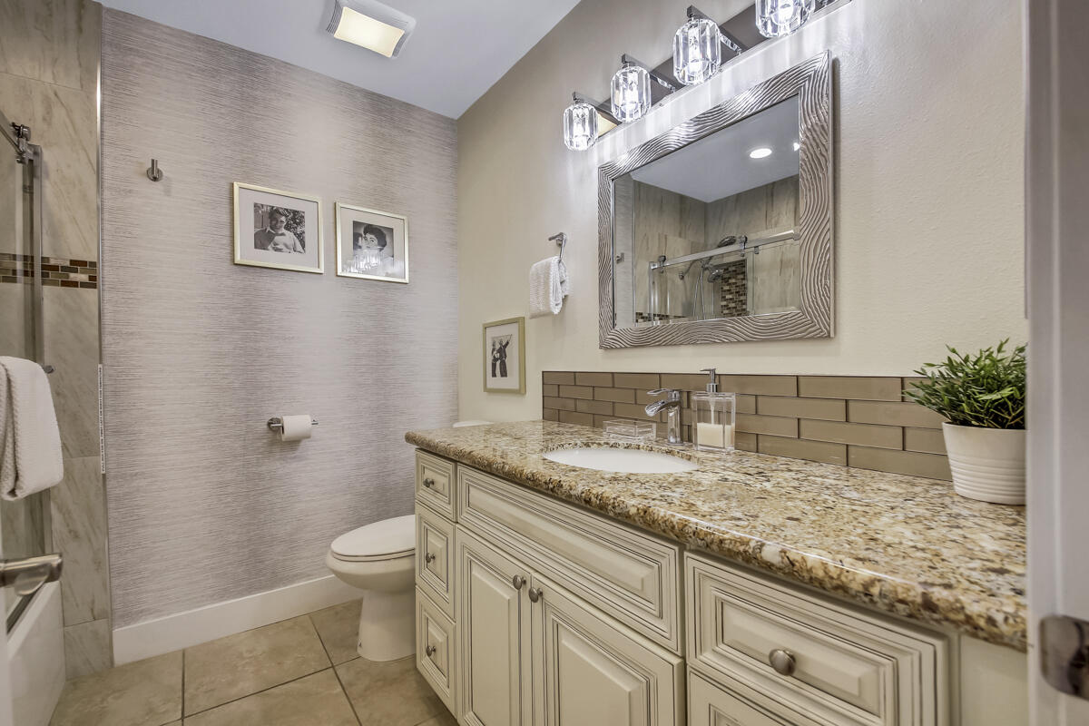 2230 Tamarisk Road Palm Springs, CA 92262 - Photo 45 of 66 a bathroom with a granite countertop sink a toilet and mirror