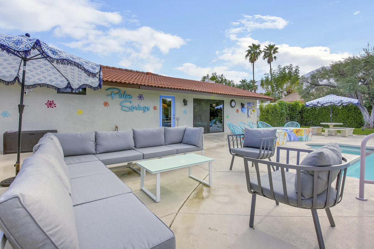 2230 Tamarisk Road Palm Springs, CA 92262 - Photo 65 of 66 a view of a patio with couches table and chairs under an umbrella with a barbeque