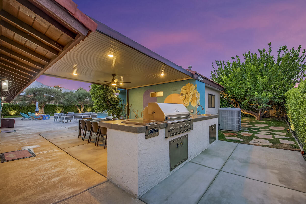 2230 Tamarisk Road Palm Springs, CA 92262 - Photo 8 of 66 a view of a patio with a table and chairs under an umbrella