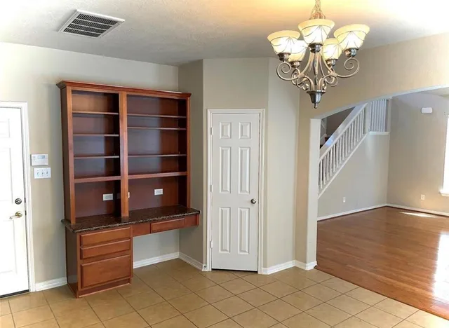 a view of staircase with railing and a chandelier