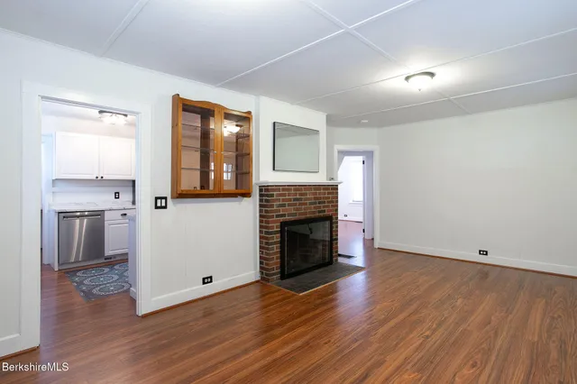a kitchen with stainless steel appliances granite countertop a refrigerator a sink and white cabinets