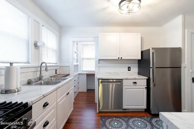 a kitchen with white cabinets and appliances