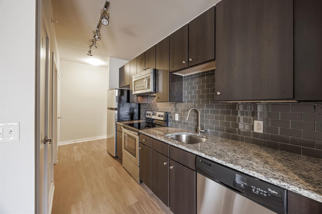 1900 Barton Springs Road, Unit 3013 Austin, TX 78704 - Photo 6 of 27 A streamlined kitchen showcasing elegant granite counters and integrated stainless steel appliances.