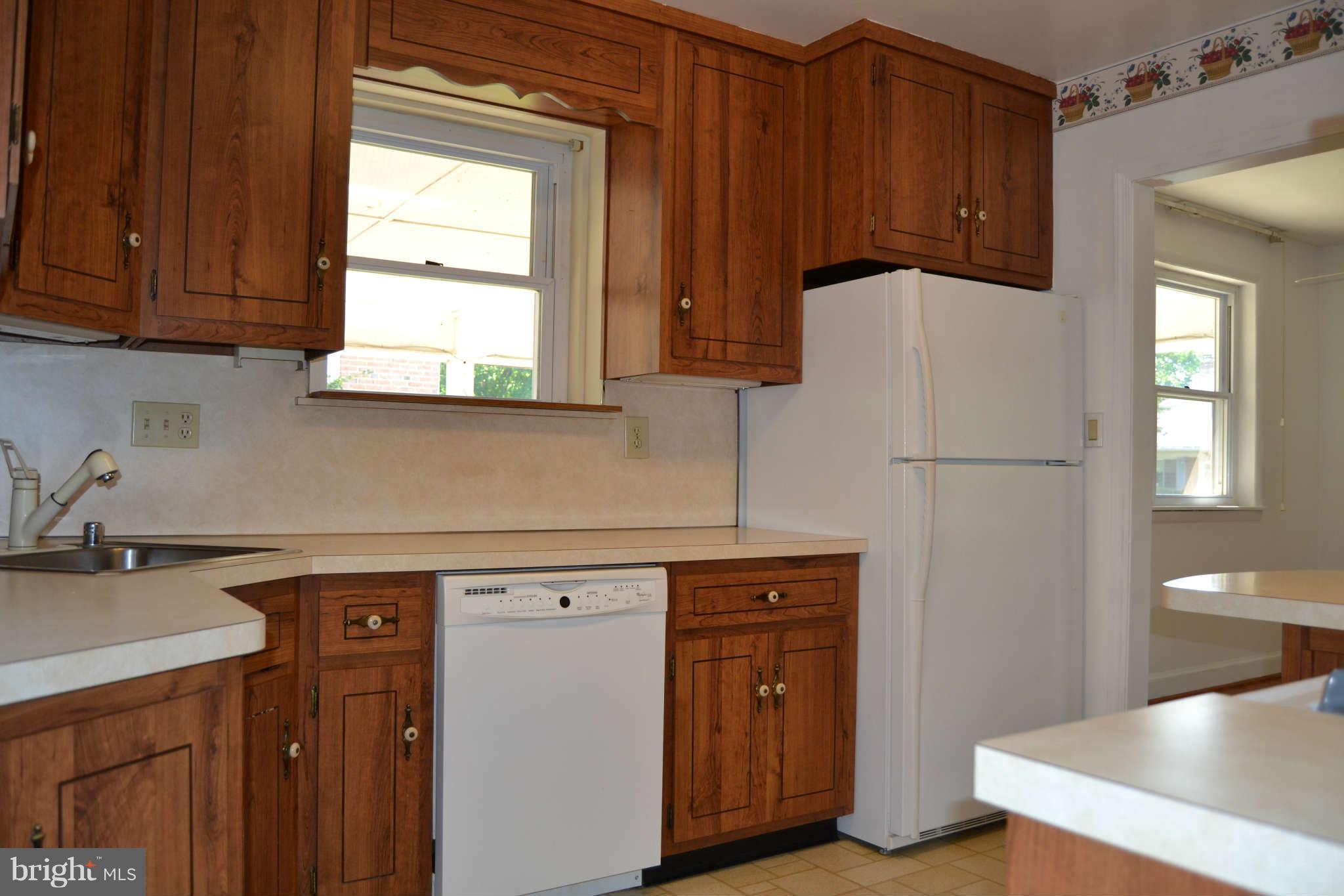423 Belton Road Silver Spring, MD 20901 - Photo 17 of 28 a kitchen with a refrigerator a sink and cabinets