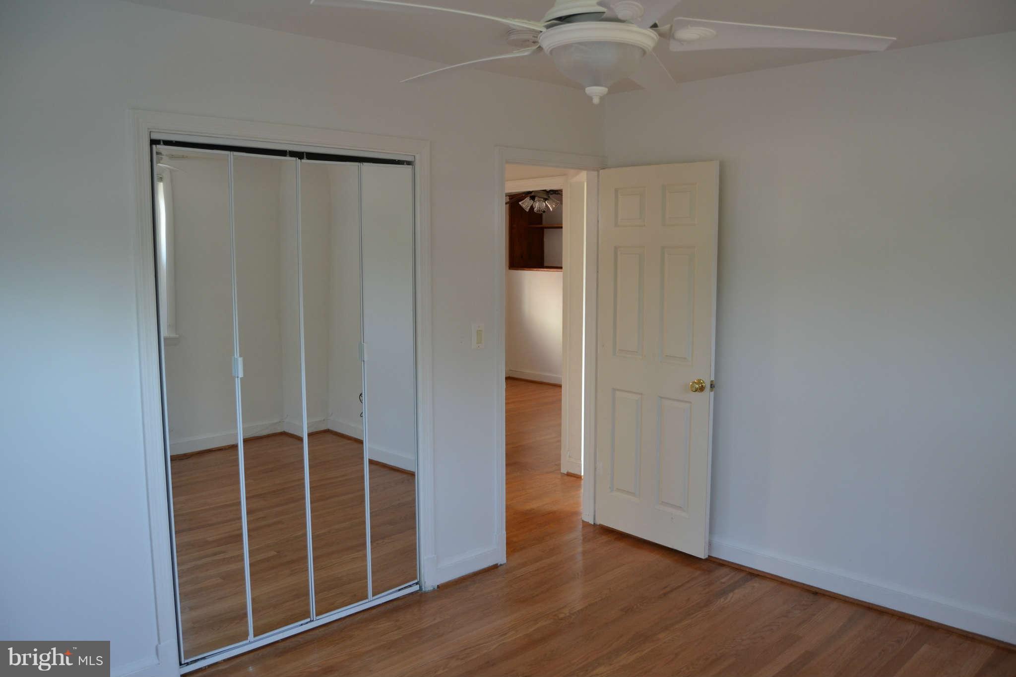 423 Belton Road Silver Spring, MD 20901 - Photo 6 of 28 an empty room with wooden floor closet and windows