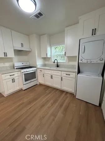 a kitchen with granite countertop a sink and cabinets