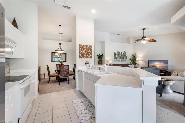 a large white kitchen with sink and washing machine