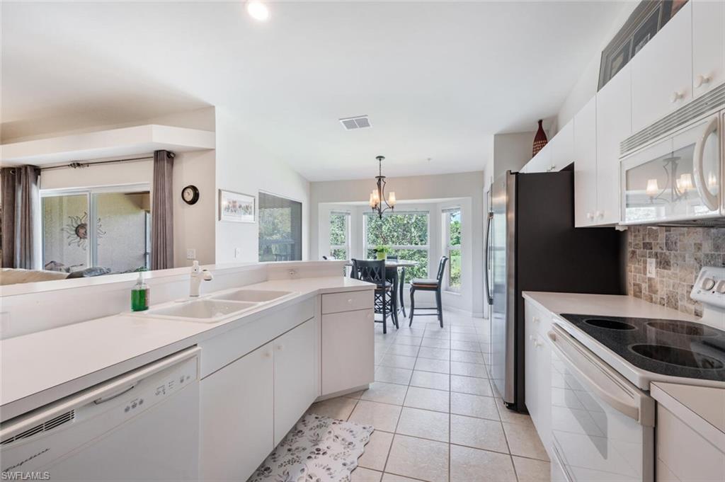 2895 Cypress Trace Circle, Unit 202 Naples, FL 34119 - Photo 13 of 30 a kitchen with a sink stove and cabinets