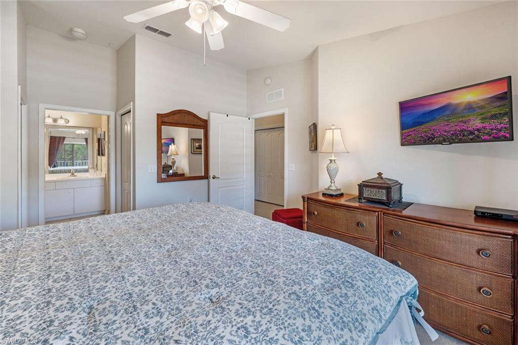 2895 Cypress Trace Circle, Unit 202 Naples, FL 34119 - Photo 18 of 30 a bedroom with a bed and a dresser