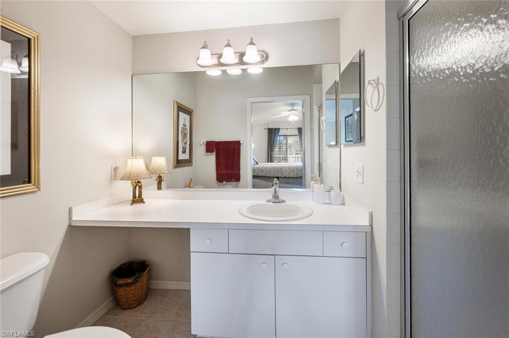 2895 Cypress Trace Circle, Unit 202 Naples, FL 34119 - Photo 19 of 30 a bathroom with a toilet a sink and mirror