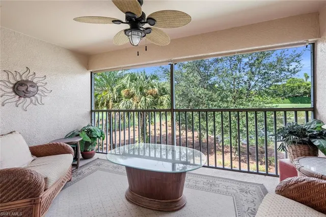 a living room with furniture and a floor to ceiling window