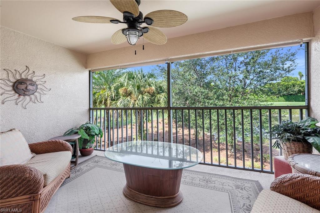 2895 Cypress Trace Circle, Unit 202 Naples, FL 34119 - Photo 23 of 30 a living room with furniture and a floor to ceiling window