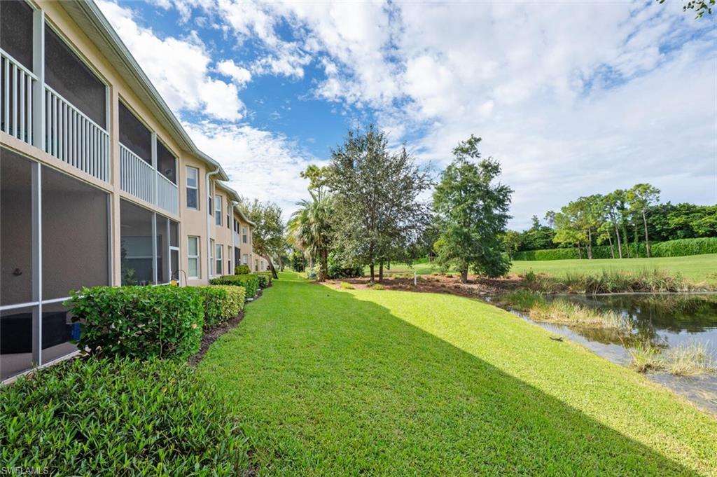 2895 Cypress Trace Circle, Unit 202 Naples, FL 34119 - Photo 28 of 30 a view of a lake with a building in the background