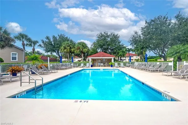 a swimming pool with outdoor seating and yard in the back
