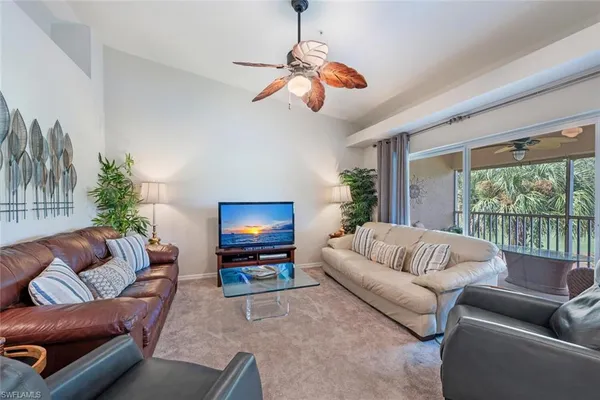 a living room with furniture a flat screen tv and a large window