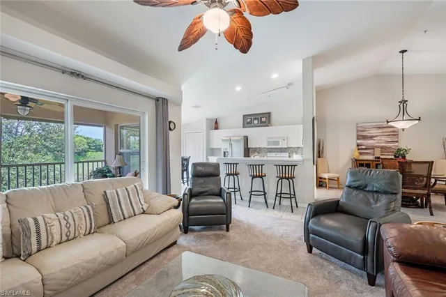 a living room with furniture kitchen view and a large window