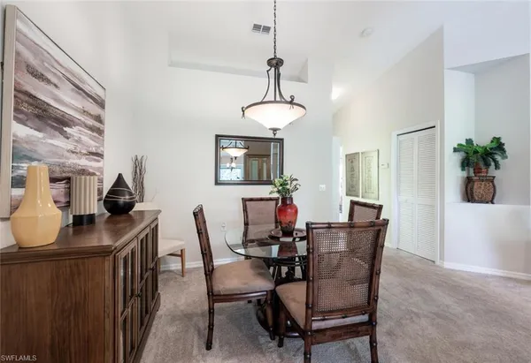 a dining room with furniture potted plants and wooden floor