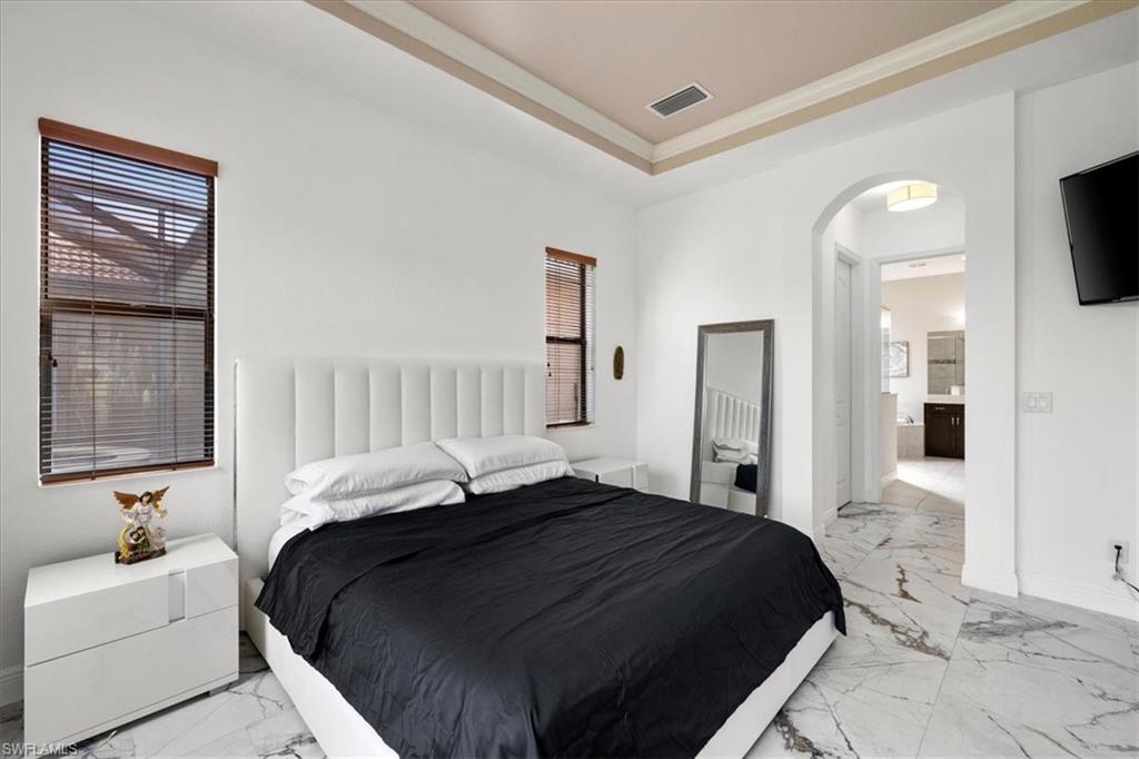 1509 Serrano Circle Naples, FL 34105 - Photo 11 of 24 a bedroom with a bed and a flat screen tv