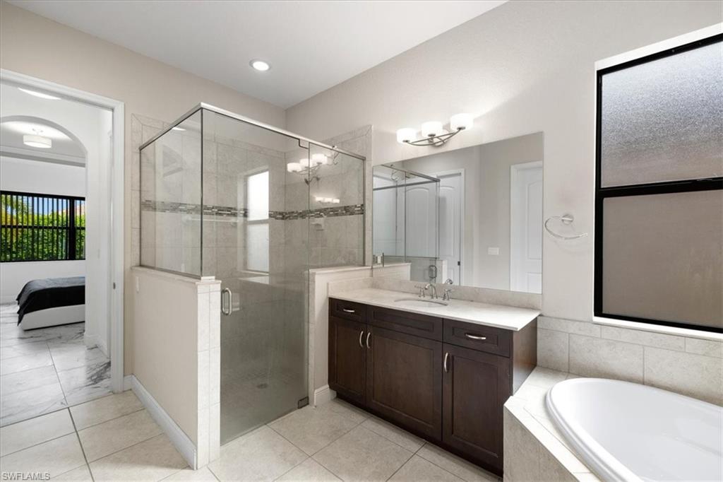 1509 Serrano Circle Naples, FL 34105 - Photo 13 of 24 a bathroom with a bathtub shower sink vanity and toilet