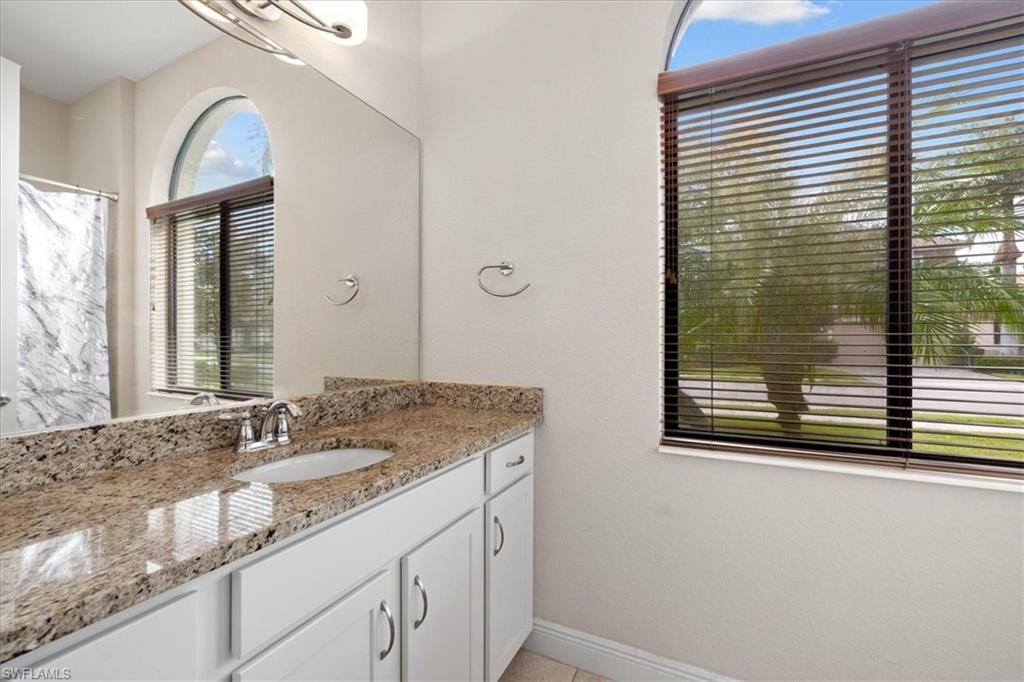 1509 Serrano Circle Naples, FL 34105 - Photo 16 of 24 a bathroom with a granite countertop sink and a mirror
