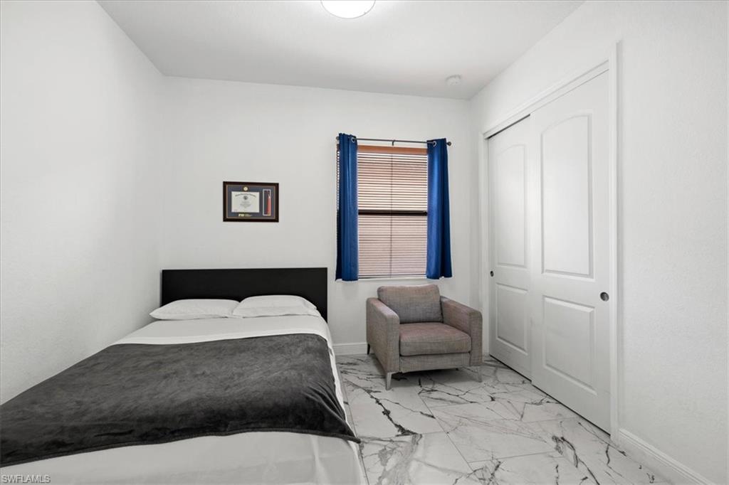 1509 Serrano Circle Naples, FL 34105 - Photo 17 of 24 a bedroom with a bed and a couch