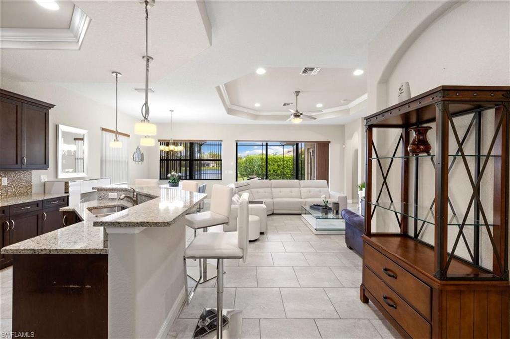 1509 Serrano Circle Naples, FL 34105 - Photo 3 of 24 a kitchen with stainless steel appliances kitchen island granite countertop a sink and a refrigerator