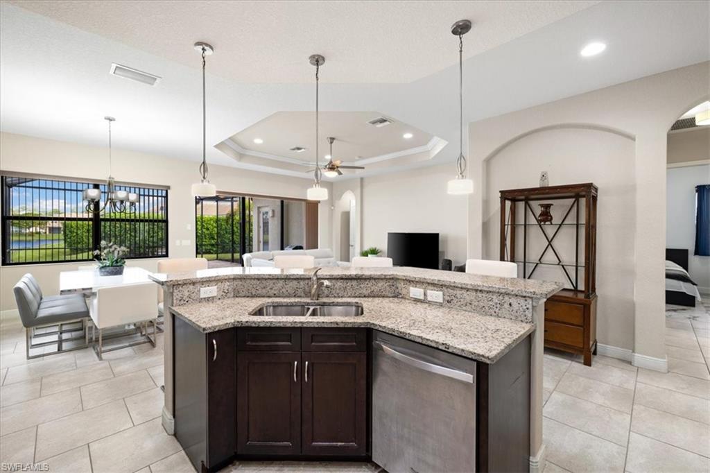 1509 Serrano Circle Naples, FL 34105 - Photo 4 of 24 a kitchen with a kitchen island a sink appliances and a counter top space
