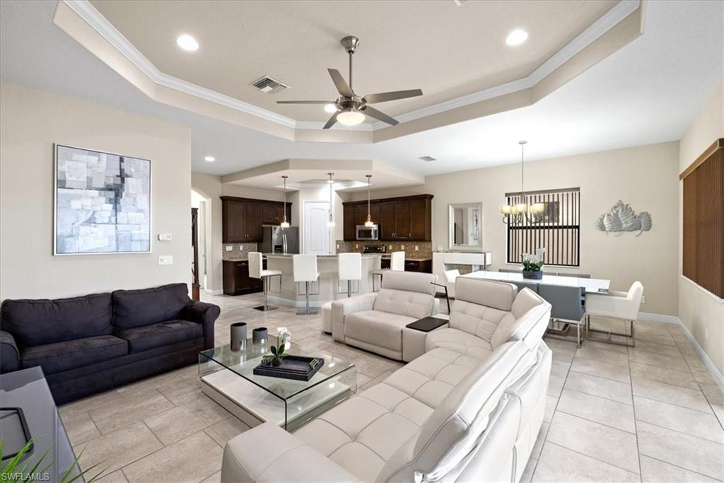 1509 Serrano Circle Naples, FL 34105 - Photo 7 of 24 a living room with furniture a ceiling fan and a rug