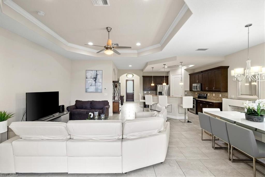 1509 Serrano Circle Naples, FL 34105 - Photo 9 of 24 a living room with furniture and a flat screen tv