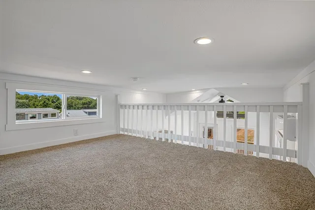 an empty room with stairs and windows